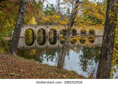 The seven arch bridge that crosses over Byrd lake in the Cumberland mountain state park surrounded by the vibrant colorful trees of autumn a mirror reflection in the water closeup