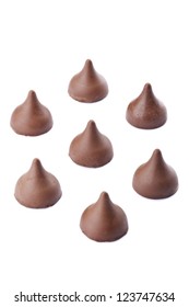Seven chocolate kisses in circular arrangement isolated in a white background