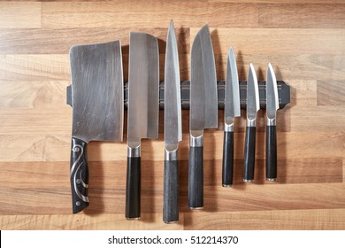 Seven kitchen knives mounted on the brown oak wall