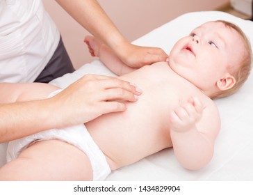 Seven Month Baby Abdomen Being Manipulated By Osteopathic Or Chiropractic Manual Therapist In A Pediatric Clinic