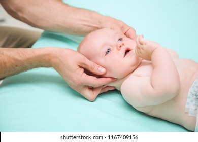 Siebmonatiger Babybourenkopf, der von einem Osteopathietherapeuten oder Arzt manipuliert wird