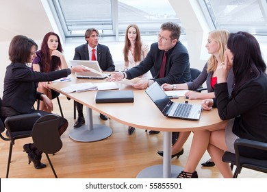 seven people having a business meeting in the conference room