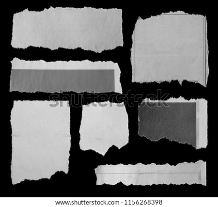 Seven pieces of torn paper on black