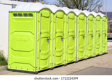 
Seven Portable Toilets, Standing Outside