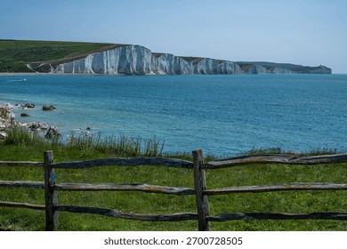 Seven Sisters. Dramatic cliffs tower over tranquil waters, with vibrant blue hues reflecting the beauty of nature, creating a stunning coastal scene filled with visual splendor