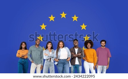Seven vibrant millennial individuals stand confidently with arms crossed, smiling in front of a blue background with the circle of stars from the European Union flag, studio, panorama