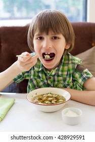 A Seven Years Kid Is Eating Russian Ravioli In Cafe