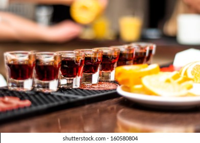 Several Alcohol Shots On Bar With Tequila And Orange Or Lemon