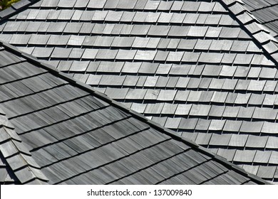 Several angled rooftops with worn and weathered wooden shingles