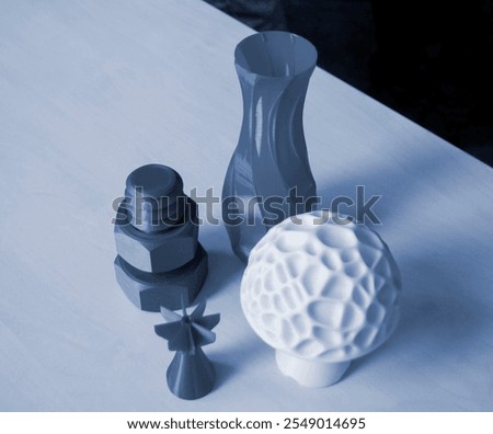 Several art objects printed on a 3D printer. Model blue vase, white mushroom, tip, gray washer and bolt created 3D printer from molten plastic. Additive progressive technology
