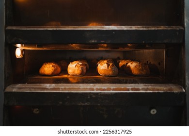 Several artisan breads being baked in a industrial oven - Shutterstock ID 2256317925