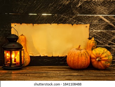 Several Assorted Small Pumpkins On A Dark Background Next To A Lighted Lantern