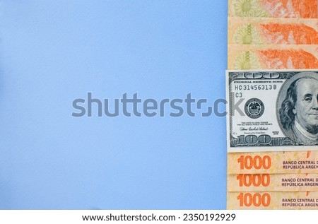 several banknotes showing half of them with one of 100 dollars in the middle and others close together of 1000 Argentine pesos all placed on the right side and the rest with a large space for text