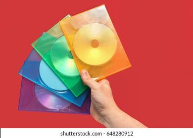 Several boxes of CD on hand with red background. Front view