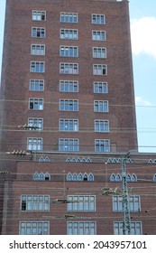 several cables run in front of the large brick building with the many windows