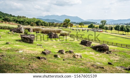 Several capstone dolmens scenery and tourists in the distance in Gochang dolmens site South Korea