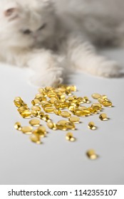 Several Capsules Of Fish Oil. Curious Cat In The Background. White And Yellow Colors