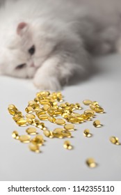 Several Capsules Of Fish Oil. Curious Cat In The Background. White And Yellow Colors