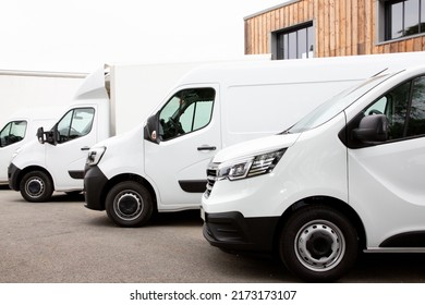 Several cars vans trucks parked in parking lot for rent delivery white vans in service van truck front of entrance of warehouse distribution logistic society