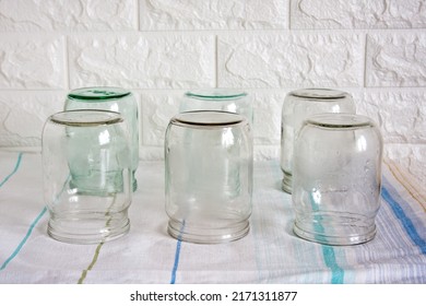 Several Clean, Empty Half-litre Glass Jars Sit Upside Down On The Kitchen Table. Time To Preserve Berries, Fruits And Vegetables.