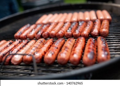 Several Cooking Hot Dogs On A Grill