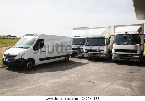 several delivery van and white logistic\
truck for service transportation in distribution\
park