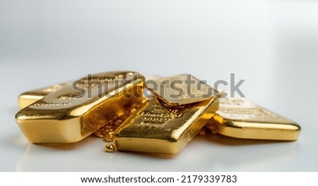 Several different gold bars lie on a pile of gold pellets. Selective focus.  