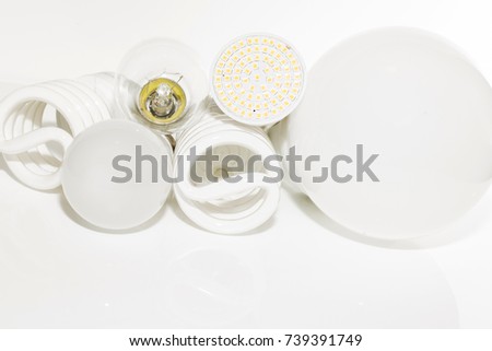 Several different led bulbs and compact fluorescent lamps with the size of the male screw base E27 on a light background