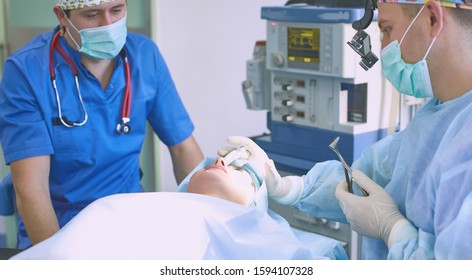 Several doctors surrounding patient on operation table during t - Shutterstock ID 1594107328