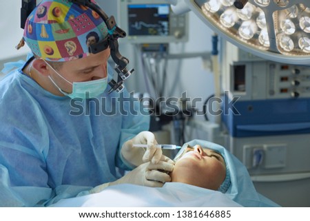 Several doctors surrounding patient on operation table during their work. Team surgeons at work in operating room