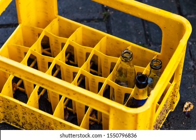 Several empty bottles in yellow plastic container