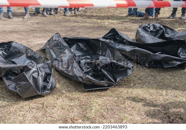 Several empty corpse body bag lie on the ground.\
People gathered around.