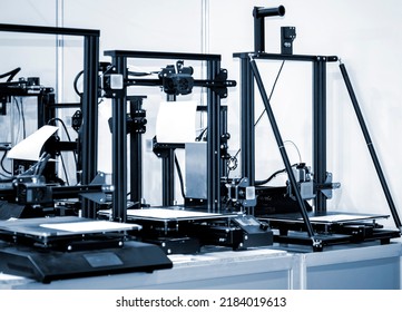 Several empty non-printing 3D printers on table. 3D printer with empty desktop. Non-printing open 3dprinter. Progressive additive modern 3D printing technology. High-precision 3D printing technologies