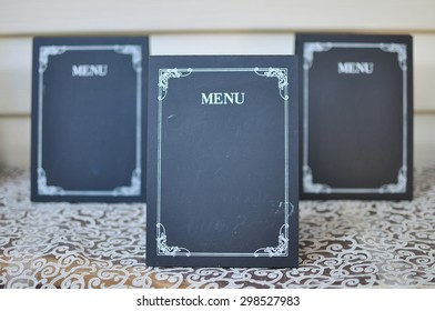 Several empty plates menu to fill the offer of the day or dish of the day .
Focus on the foreground , the rear plate in the blur . Vintage piece lumber for writing with chalk. Mock up board