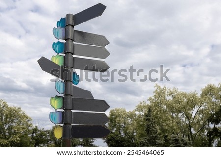 Several empty signs with direction indicators against a cloudy sky. Place for text. horizontal. Indicators of movement towards the goal for tourists