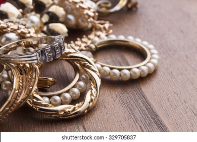 several  fashionable women's jewelry on wooden surface