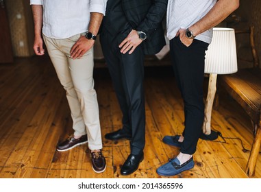 Several Gentlemen, Businessmen Men Stand In The Office On The Wooden Floor, Showing Watches, Shoes. Working Environment. Photography, Concept.