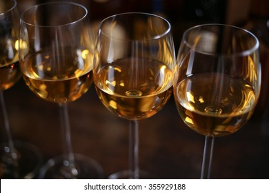 Several Glasses Of White Wine Chardonnay In A Bar Or Restaurant In The Background Bottles With Alcohol.