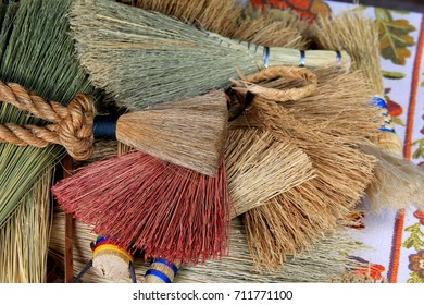 Several Handmade Brooms Set On Table In Shop, Ready For Shoppers To Chose One.