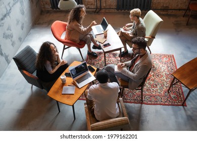 Several Intercultural Business People Interacting By Tables In Office