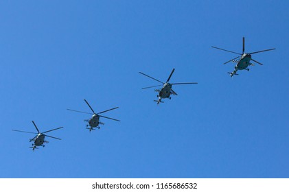 Several Military Helicopters Fly Side By Side Against The Blue Sky