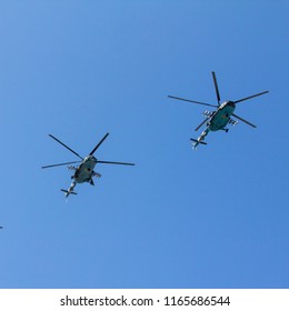 Several Military Helicopters Fly Side By Side Against The Blue Sky