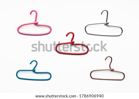 Several multi-colored metal hangers on a white background made of paper clips
