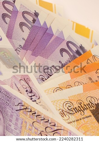 several new GBP £ Sterling Twenty 20 and Ten 10 pound notes in a small fanned stack