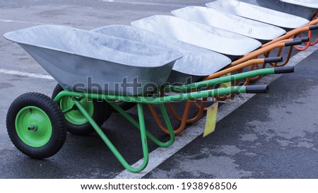 several new two-wheeled carts on sale at the beginning of the garden spring season, garden and building hand tools in a specialized store, tools for gardening and construction