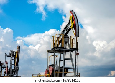 Several Oil Pump Jacks In The Background Of The Cloudy Sky.