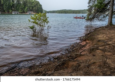 Several Older Men Fishing Together On A Fishing Motorboat Near The Shoreline On Lake Lanier, Georgia On A Bright Day In Summertime