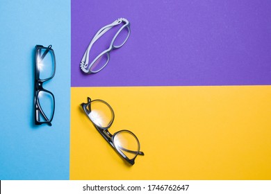 several pairs of glasses lie on a colored background, glasses for adults and children, top view, copy location, top view