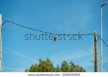 Several pairs of sports shoes hanging from electrical cables. Foto d'archivio © 
