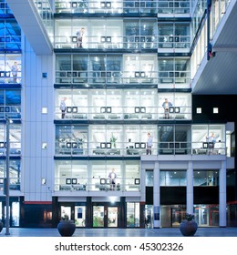 Several People Standing In Various Cubicles Of A Huge Modern Office Building